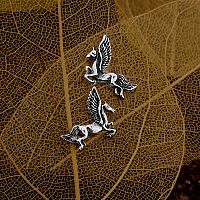 Silver Pegasus Post Earrings on a backdrop of delicate leaf skeletons, accentuating their dainty design.