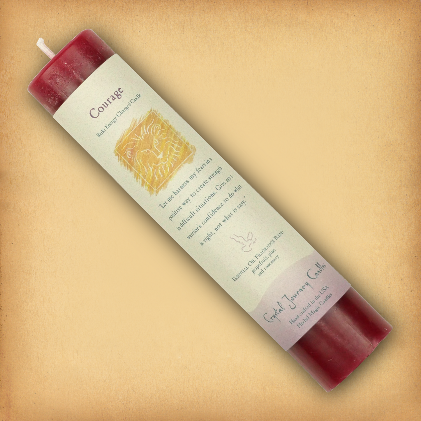 Red Reiki-charged Courage Pillar Candle, displayed diagonally to show its label with affirmation and essential oil blend.