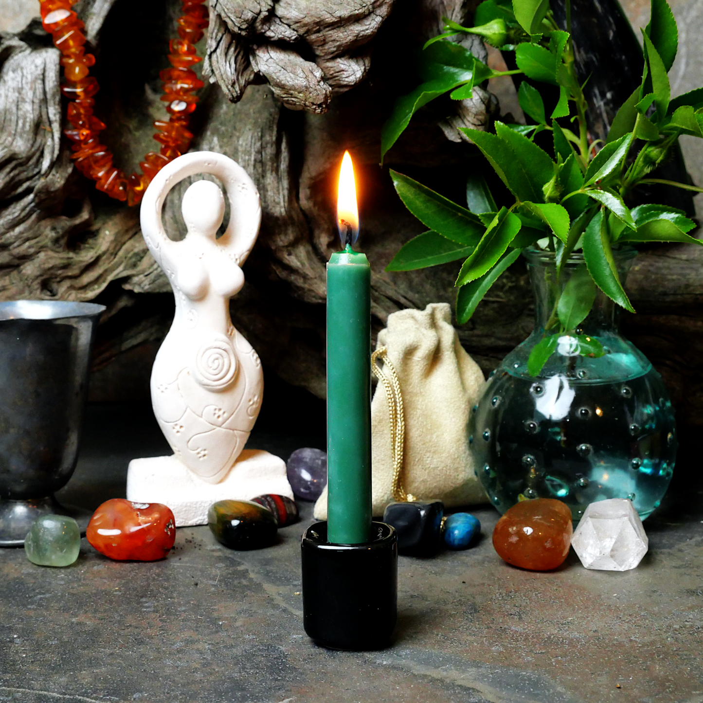 A lit forest Green Chime Candle, in a personal altar display, showing how it might be used in a ritual or ceremonial setting.