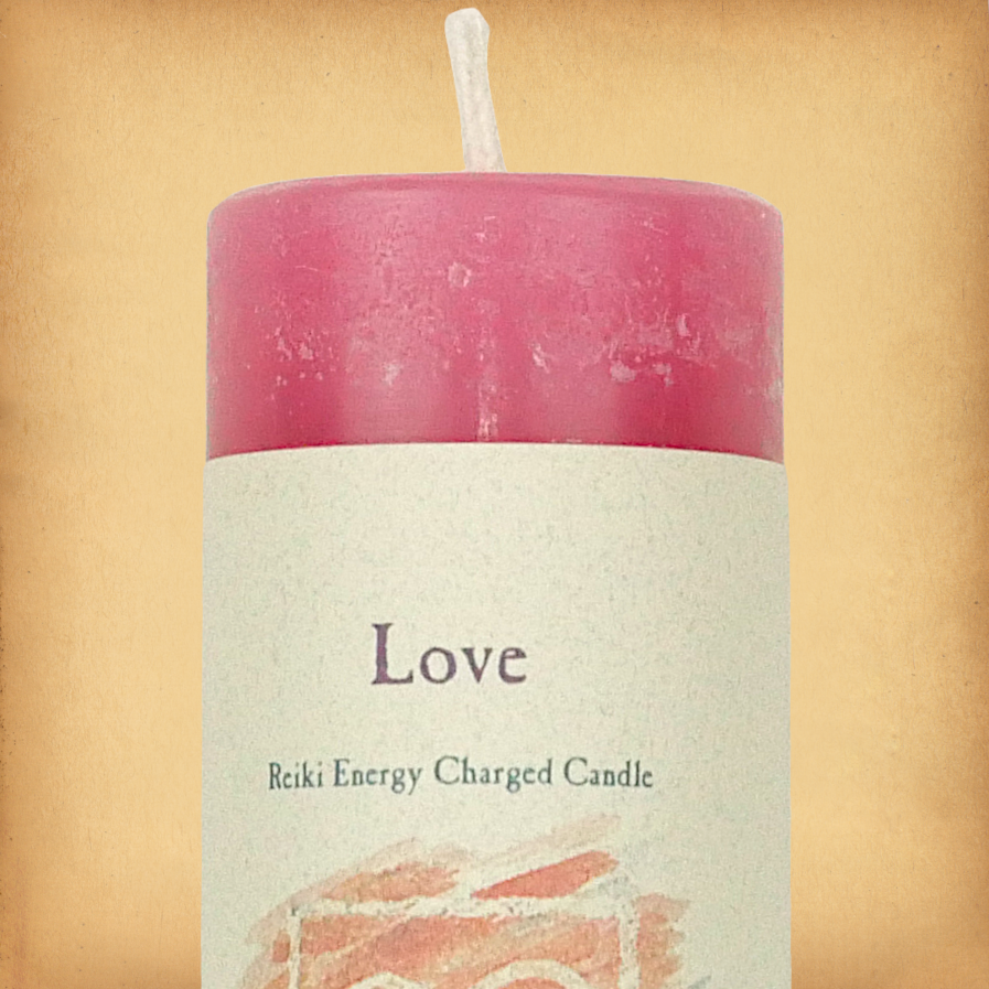 Pink pillar candle labeled “Love” with “Reiki Energy Charged Candle” beneath. Slim pillar candle with a single wick.