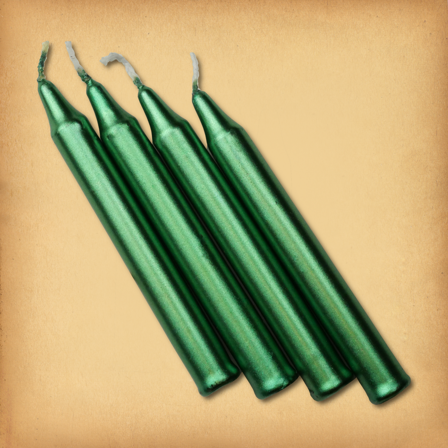 An overhead view of four Metallic Green Chime Candles, diagonally placed on a plain surface, showing the candles' proportions