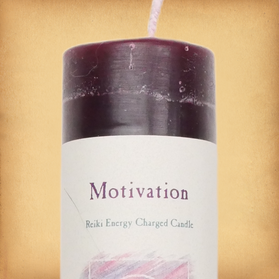 Dark red pillar candle labeled “Motivation” with “Reiki Energy Charged Candle” beneath. Slim pillar candle with a single wick
