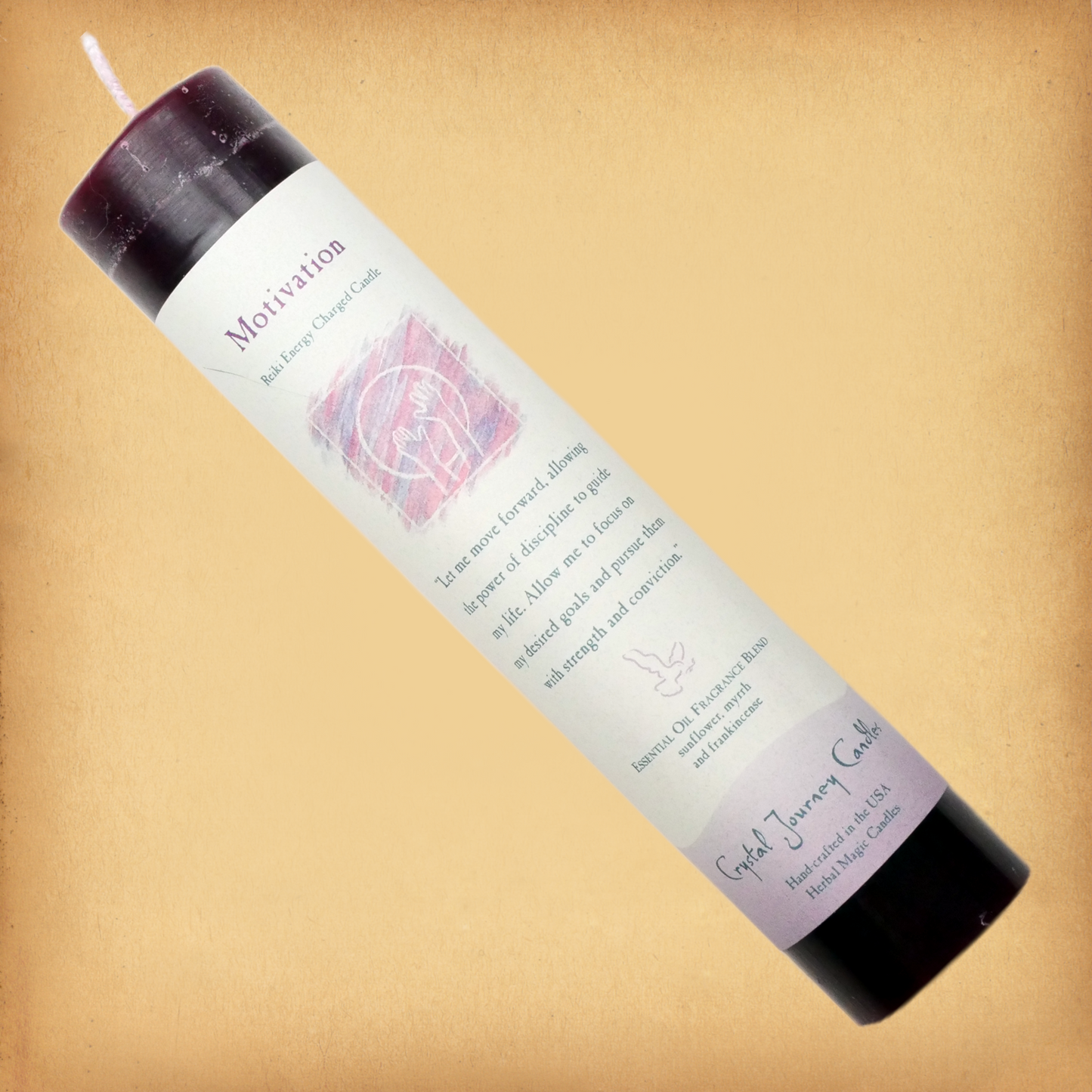 Dark red Reiki-charged Motivation Pillar Candle, displayed diagonally to show label with affirmation and essential oil blend.