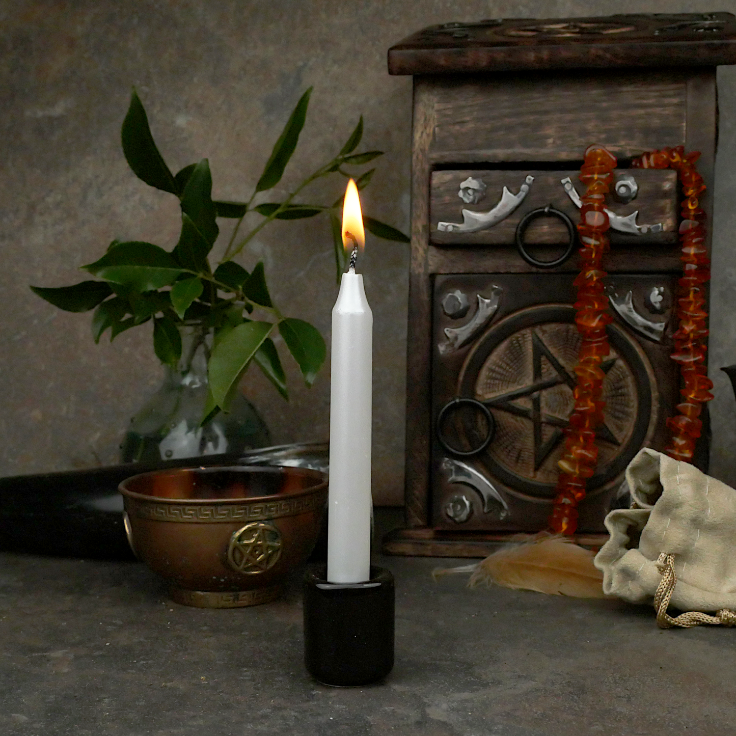 A lit Pearl White Chime Candle, in a personal altar display, showing how it might be used in a ritual or ceremonial setting.