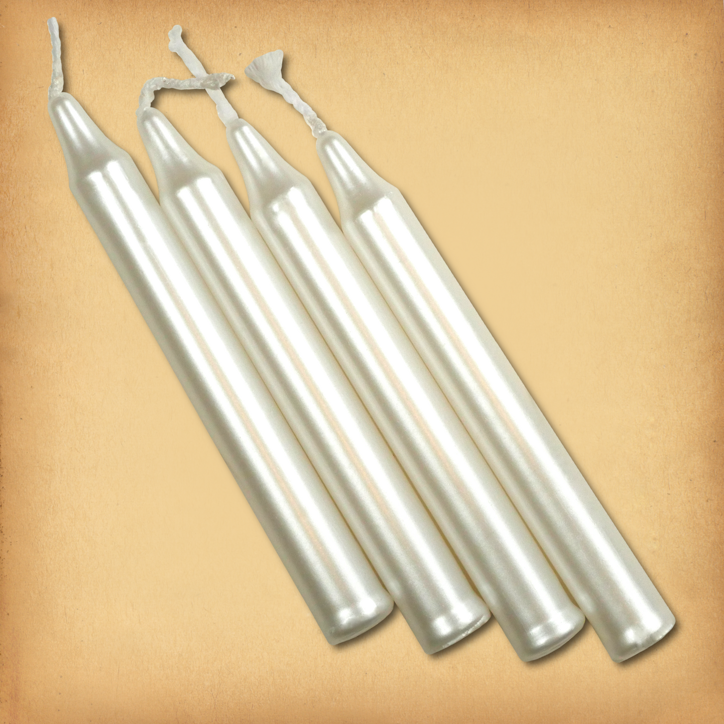 An overhead view of four Pearl White Chime Candles, diagonally placed on a plain surface, showing the candles' proportions.