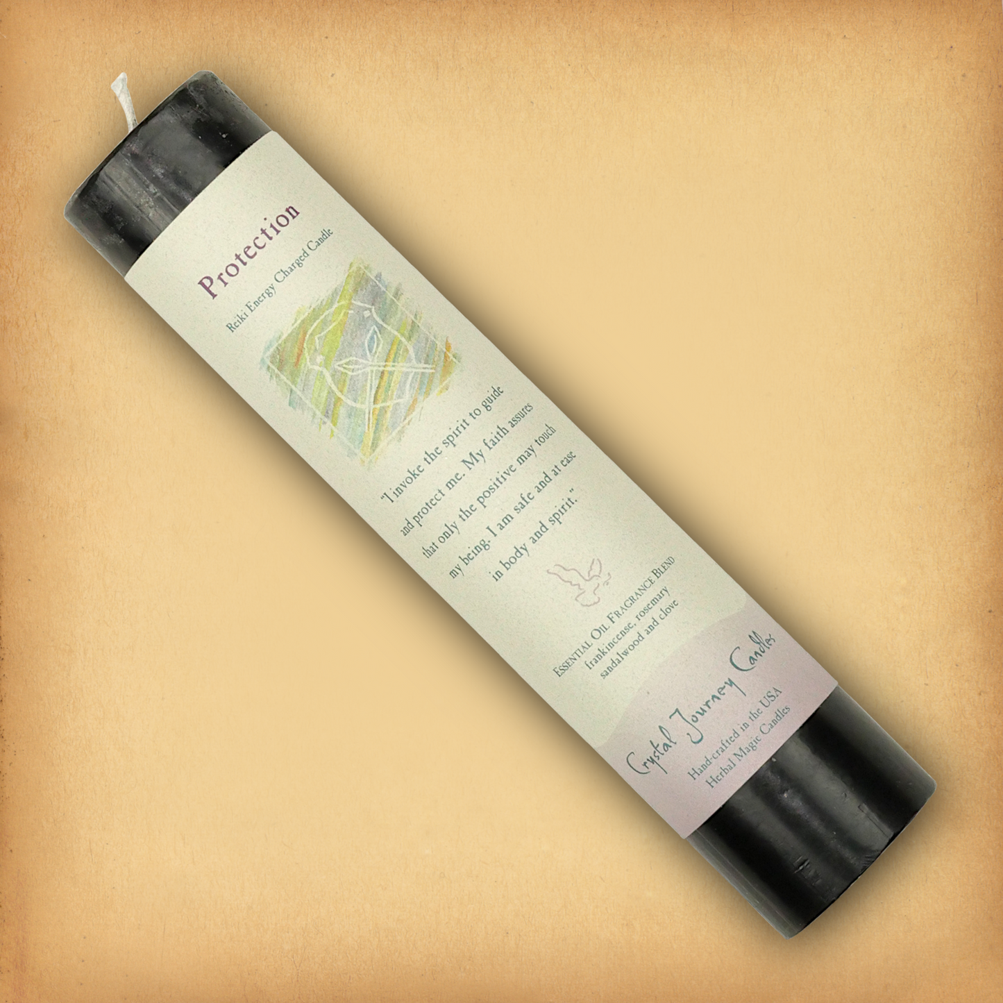 Black Reiki-charged Protection Pillar Candle, displayed diagonally to show its label with affirmation and essential oil blend