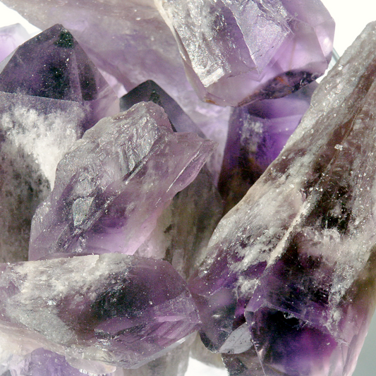 Amethyst gemstone lasers with deep purple terminations and natural rough textures, showing their characteristic tapered form.