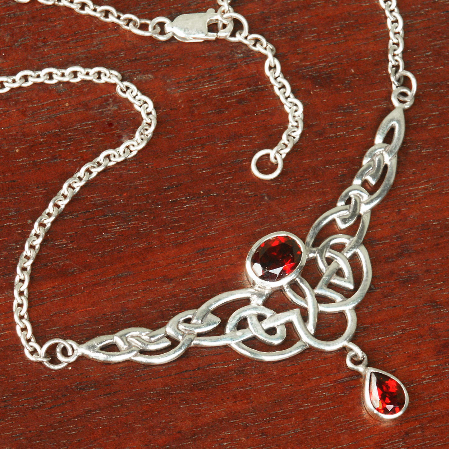 Sterling Silver Celtic Passion Necklace, showcasing the brilliance of its garnet gems set in the sterling silver Celtic knots