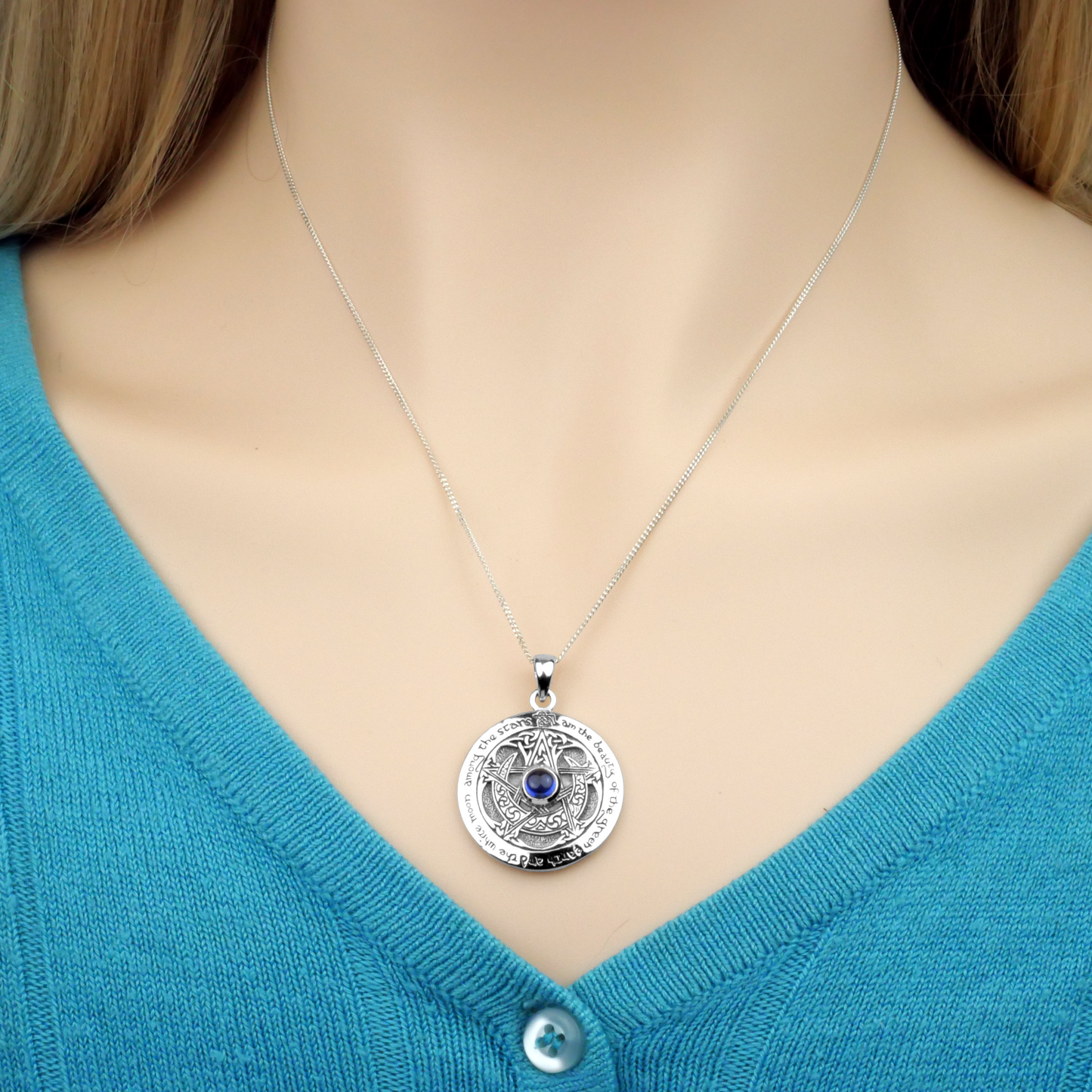 Silver Sapphire Moon Pentacle Pendant, worn by a model, on an 18" chain resting just above the neckline of a v-neck sweater.