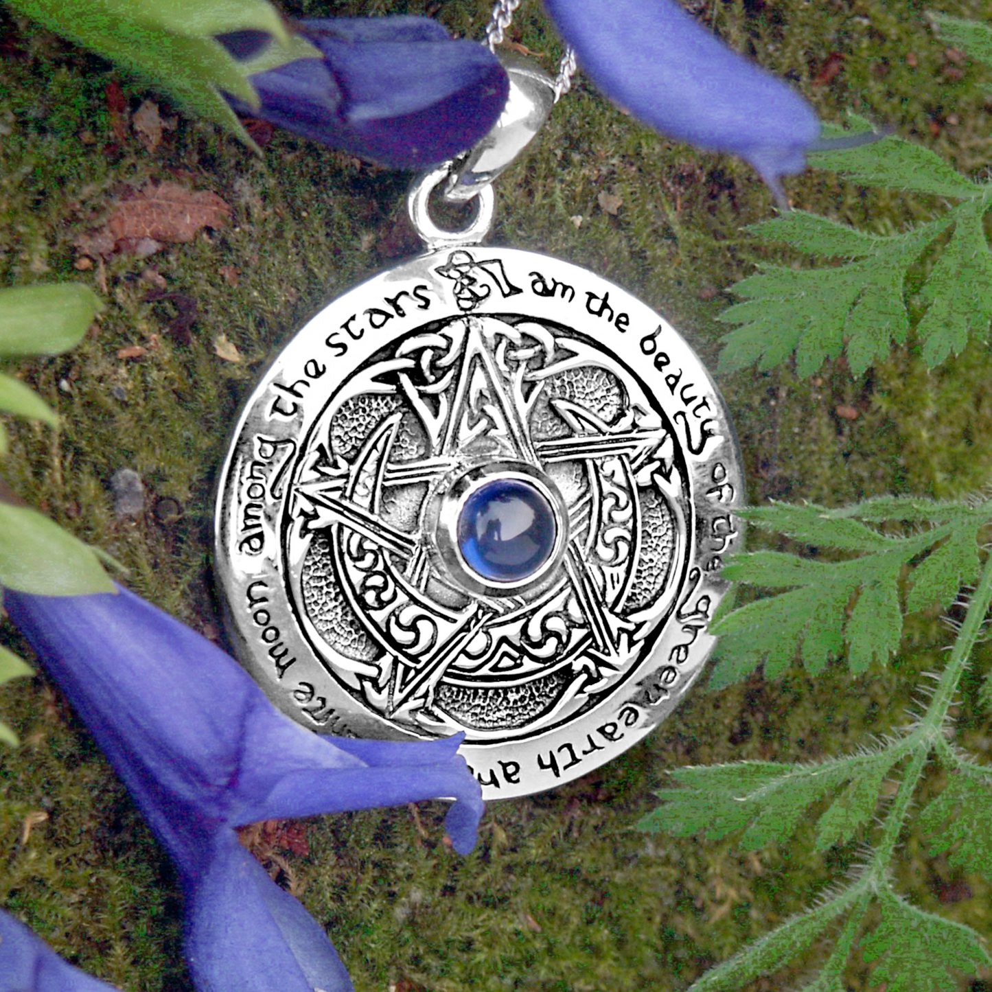 Celtic-inspired Silver Sapphire Moon Pentacle Pendant placed among ferns and flowers. Perfect jewelry for pagans and wiccans.