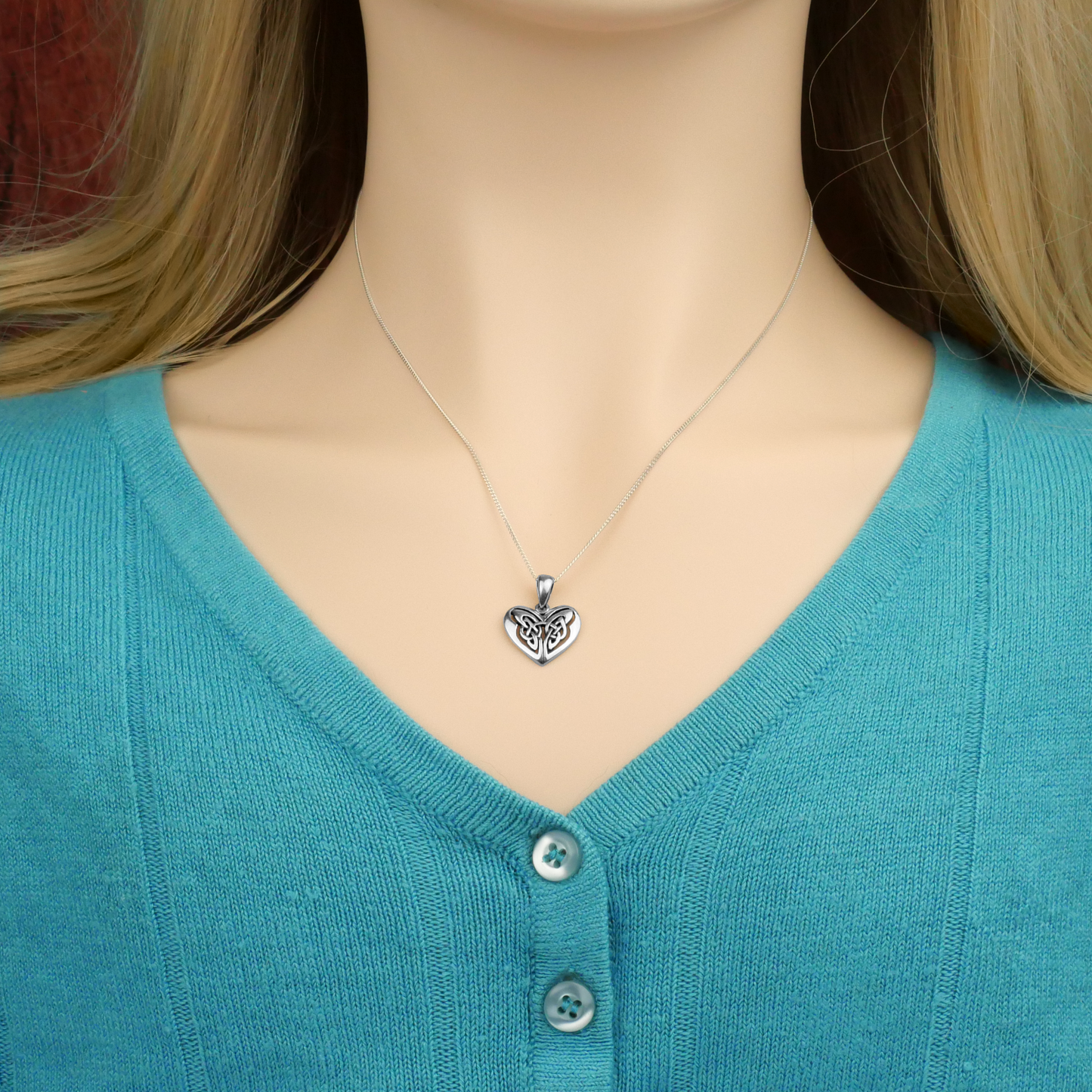 Sterling Silver Celtic Heart Pendant worn on an 18” silver chain, modeled to display its size. A timeless expression of love!