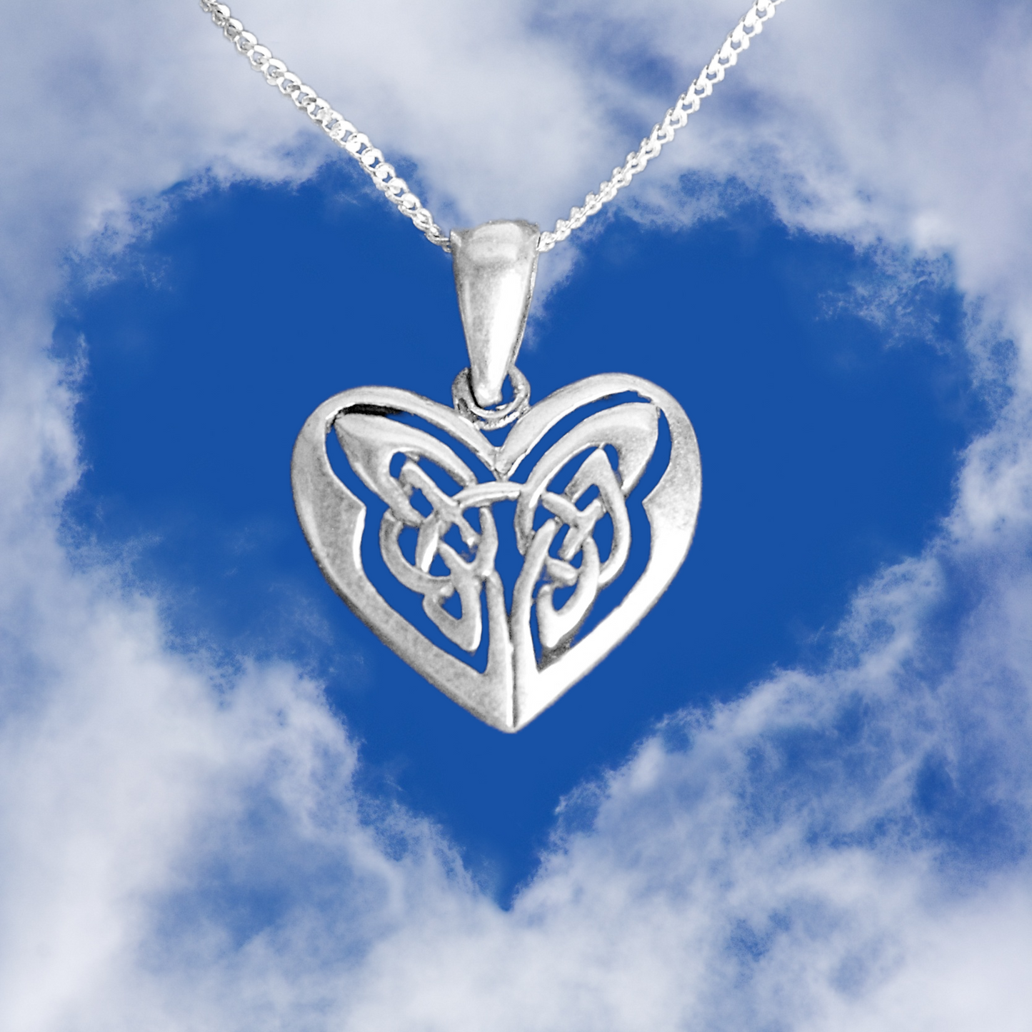 Silver Celtic Heart Pendant, symbolizing love and romance, suspended against a vibrant blue sky and heart-shaped clouds.