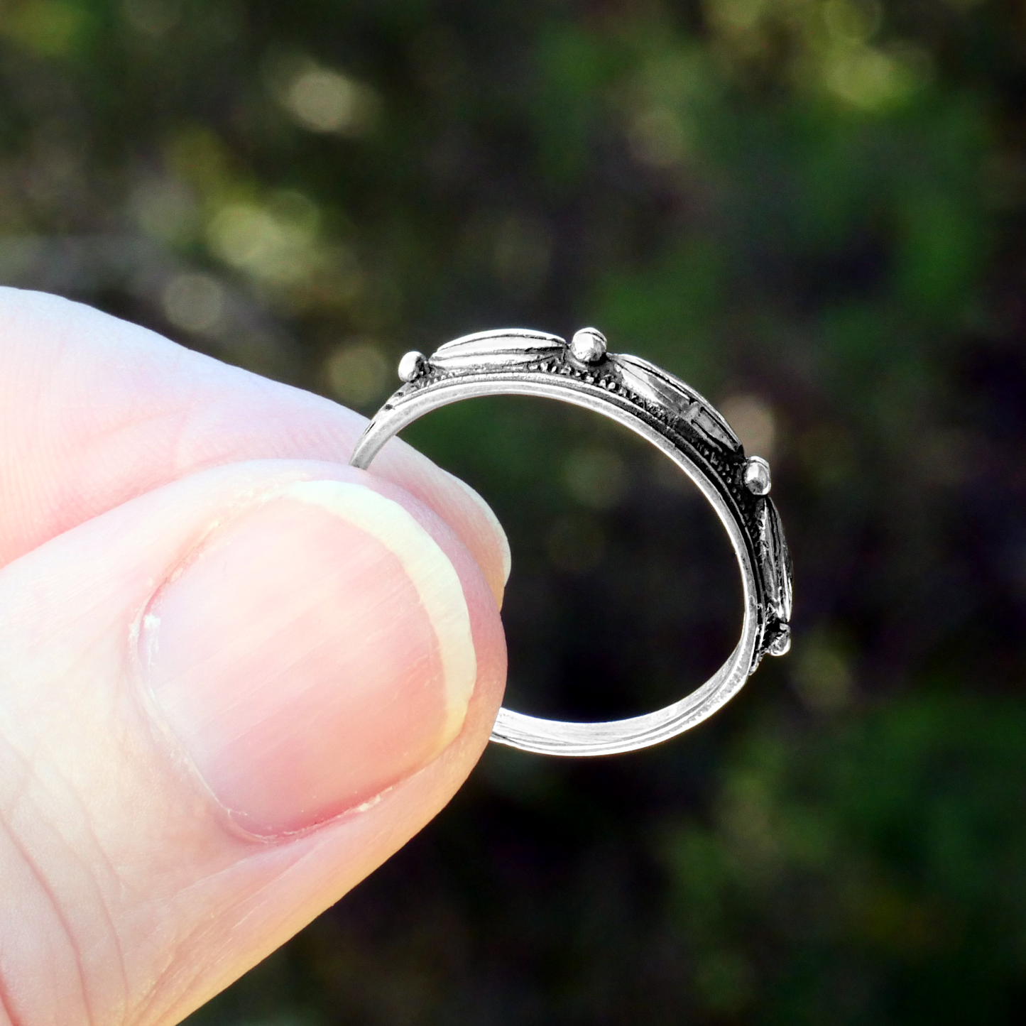 "Touch of Silver" Ring, displayed close-up while held, clearly showing the textured oval and dot pattern on the band.