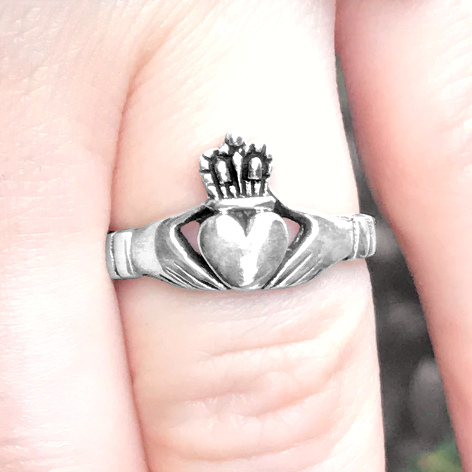 Closeup of the Silver Irish Claddagh Ring on a finger, emphasizing its delicate design and comfortable fit.
