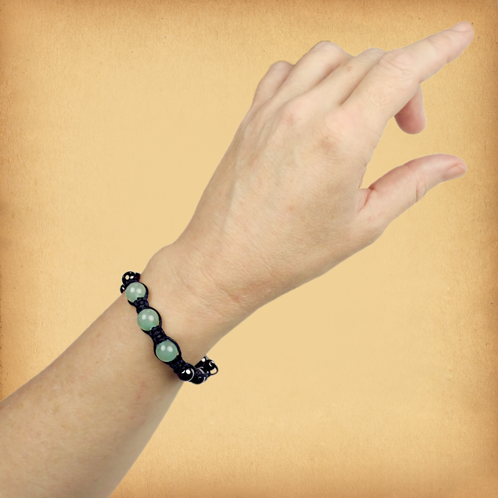 Green Aventurine Shamballa Bracelet being worn on a female wrist, showing the three larger accent beads in pastel green.