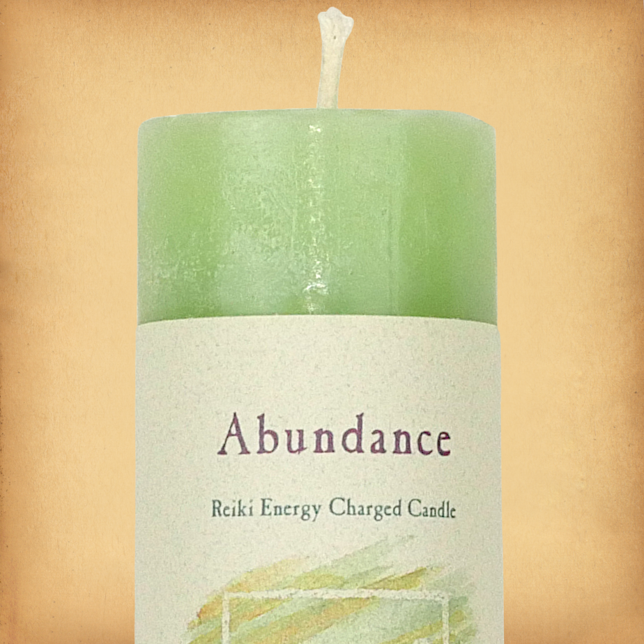 Green pillar candle labeled “Abundance” with “Reiki Energy Charged Candle” beneath. Slim pillar candle with a single wick.