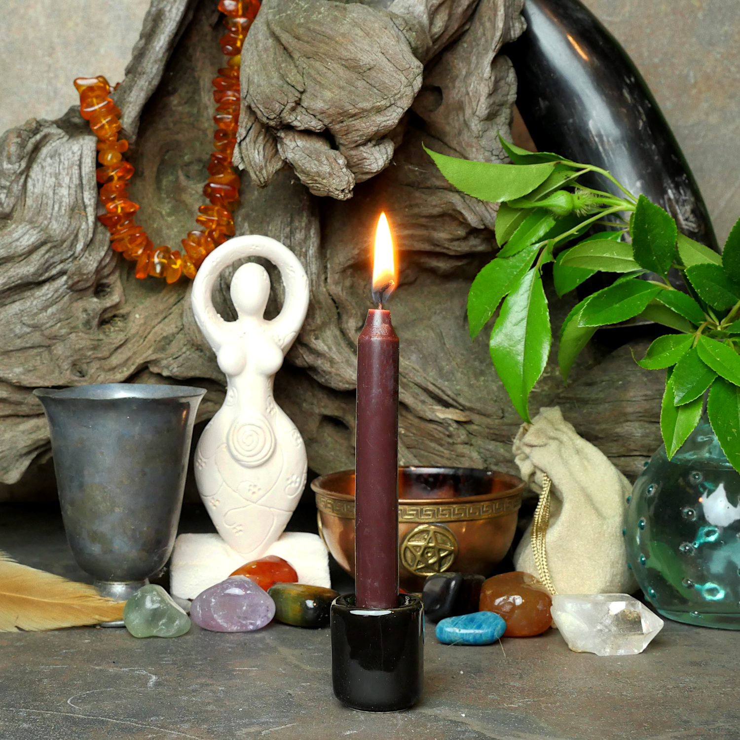 A lit Brown Chime Candle, in a personal altar display, showing how it might be used in a ritual or ceremonial setting.