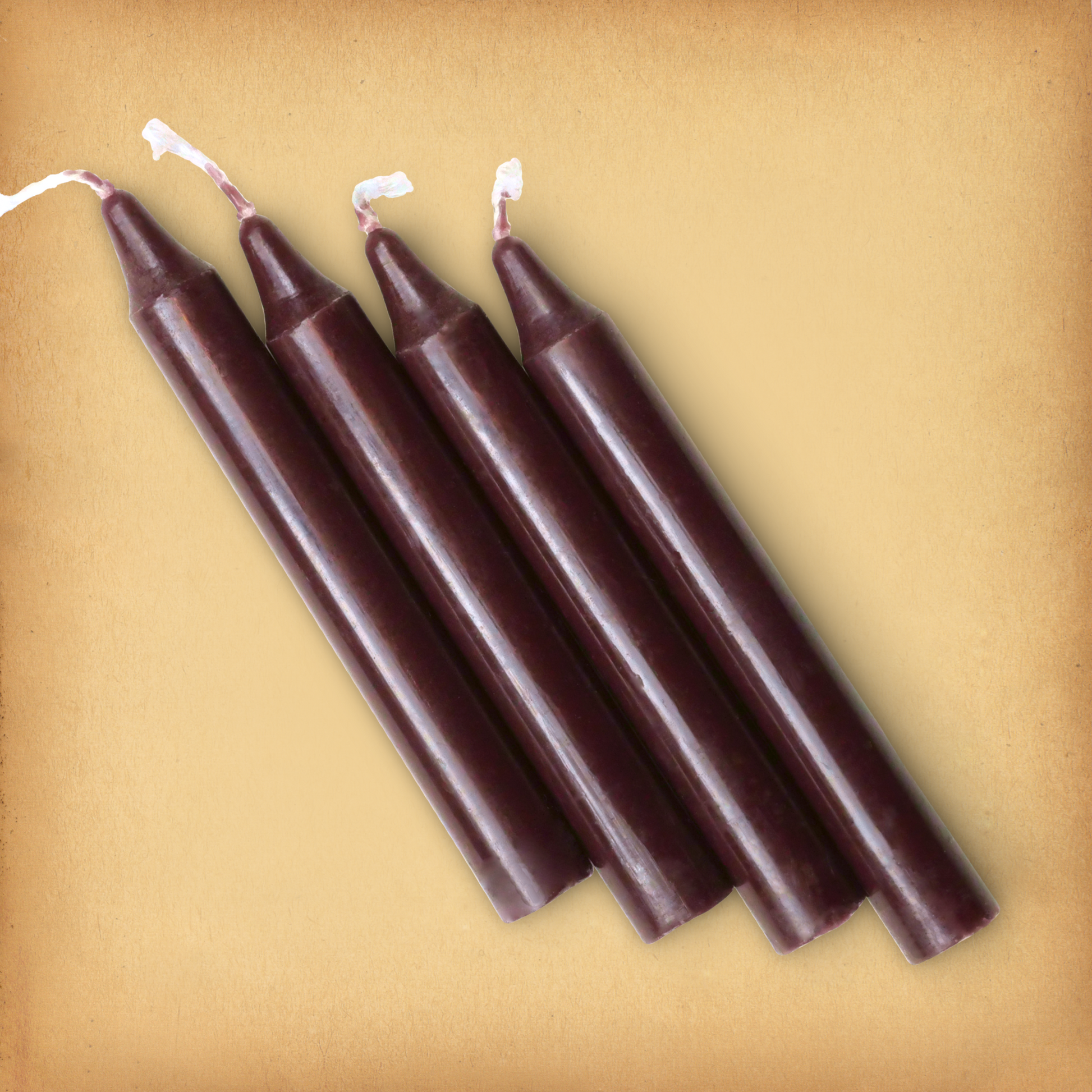 An overhead view of four Brown Chime Candles, diagonally placed on a plain surface, showing the candles' proportions.