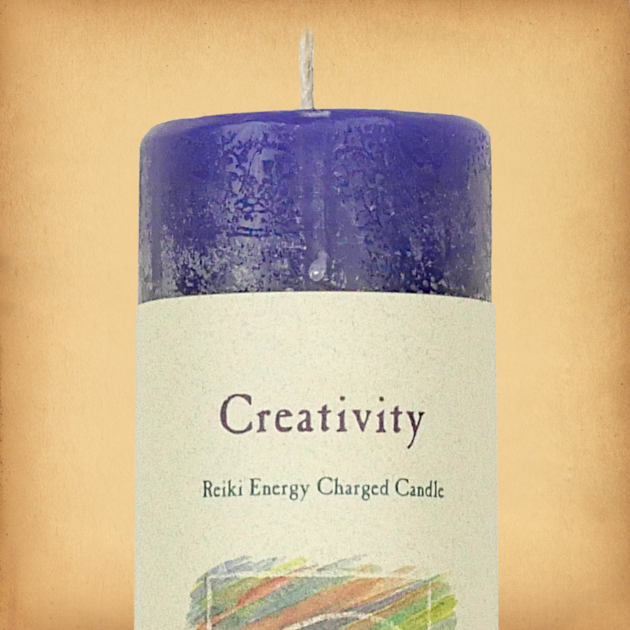 Blue pillar candle labeled “Creativity” with “Reiki Energy Charged Candle” beneath. Slim pillar candle with a single wick.