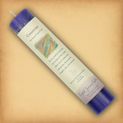 Blue Reiki-charged Creativity Pillar Candle, displayed diagonally to show its label with affirmation and essential oil blend.