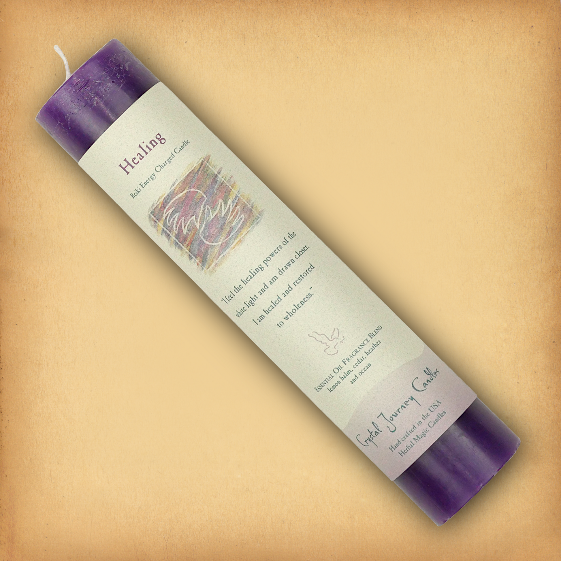 Purple Reiki-charged Healing Pillar Candle, displayed diagonally to show its label with affirmation and essential oil blend.