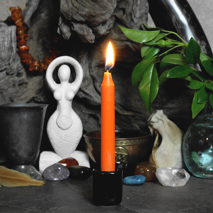 A lit Orange Chime Candle, in a personal altar display, showing how it might be used in a ritual or ceremonial setting.