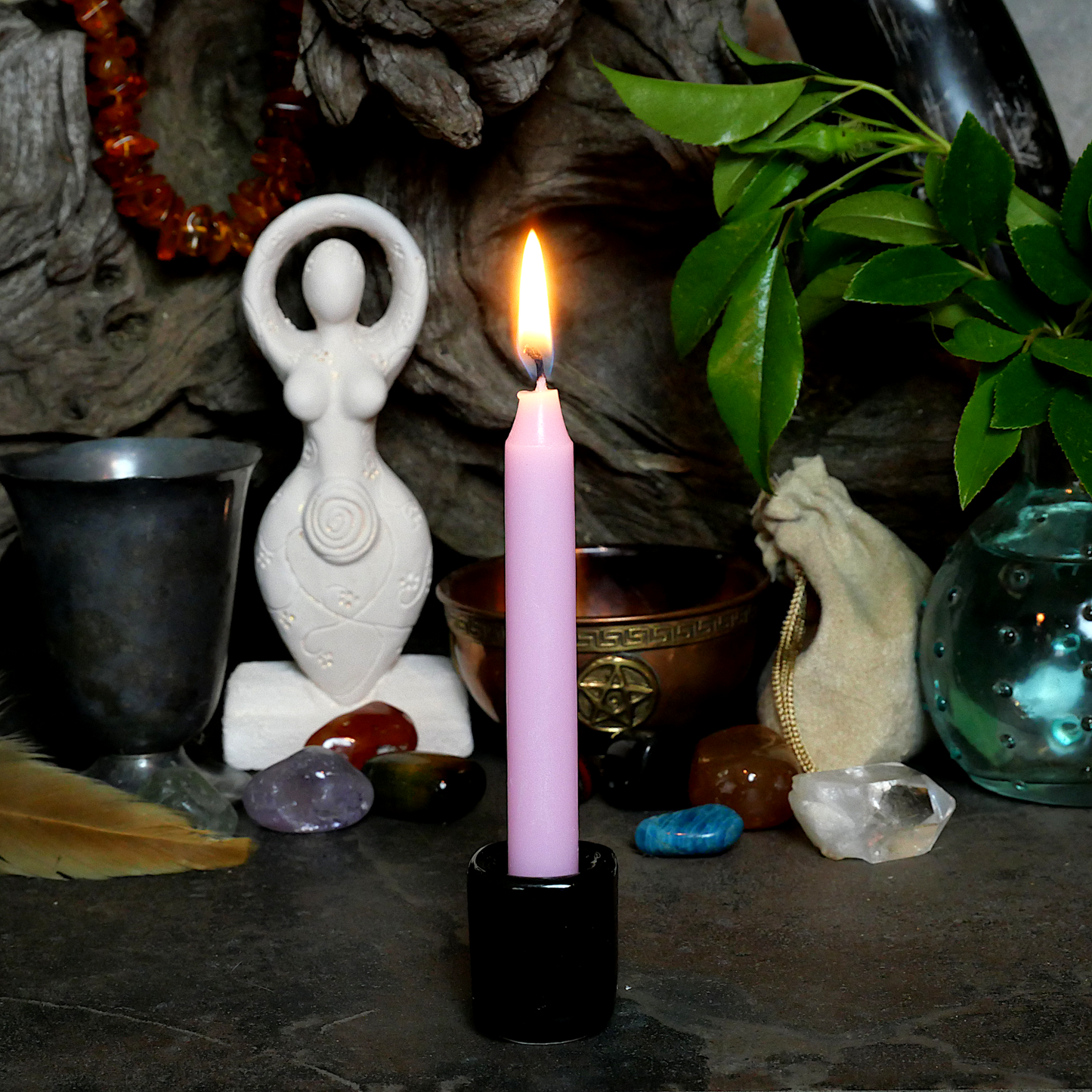 A lit Pink Chime Candle, in a personal altar display, showing how it might be used in a ritual or ceremonial setting.