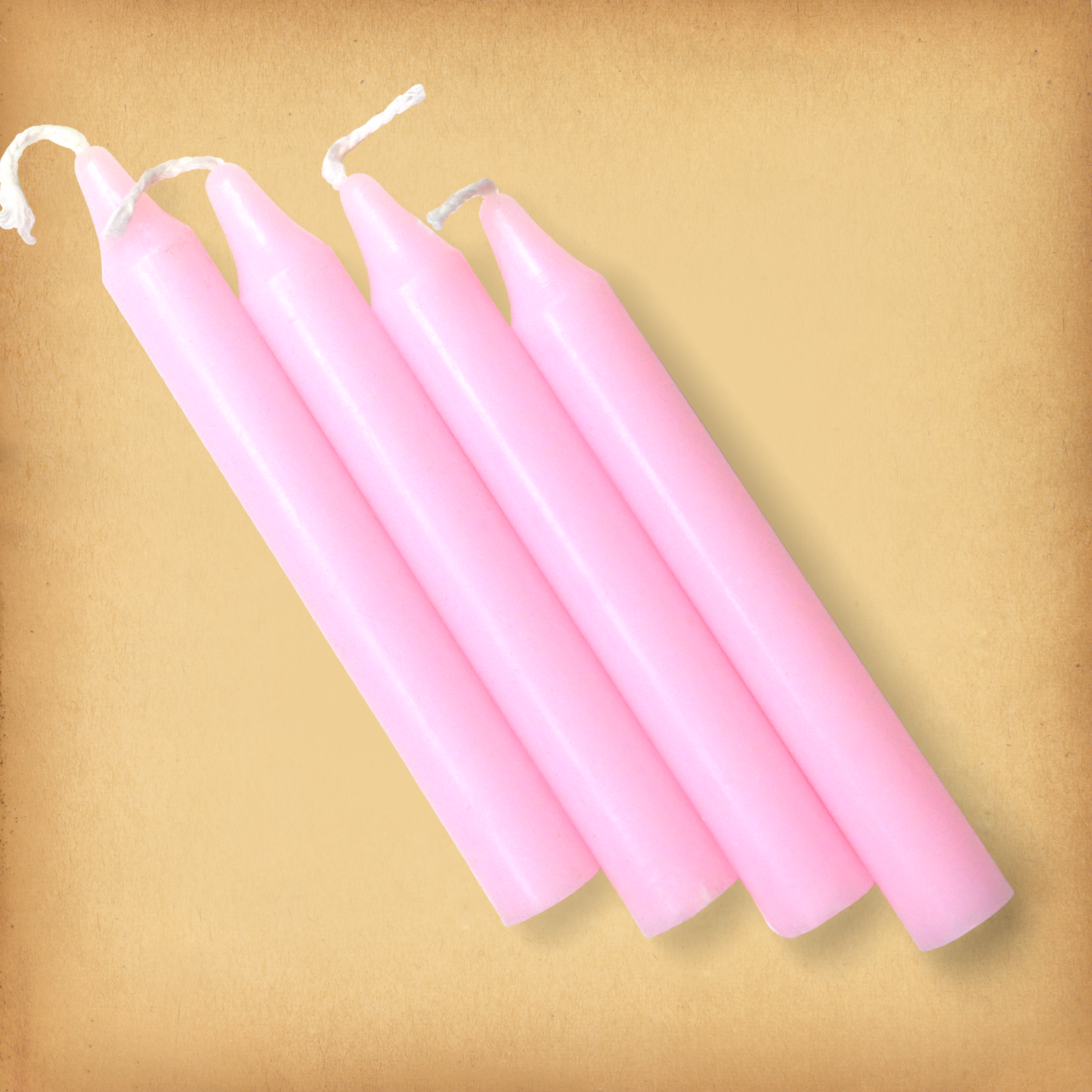 An overhead view of four Pink Chime Candle, diagonally placed on a plain surface, showing the candles' proportions.