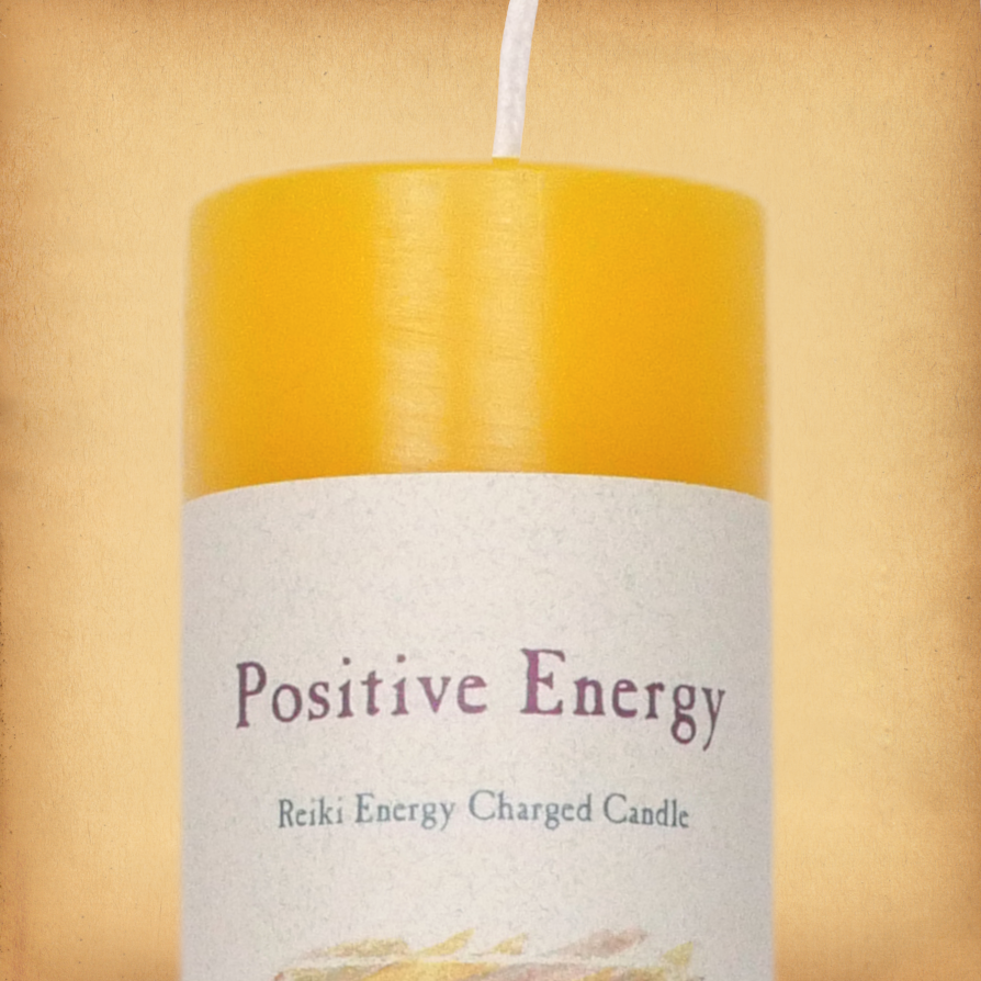 Yellow pillar candle labeled “Positive Energy” with “Reiki Energy Charged Candle” beneath. Slim pillar candle w/ single wick.