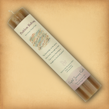 Brown Reiki-charged Problem Solving Pillar Candle, laid diagonally to show its label with affirmation and essential oil blend