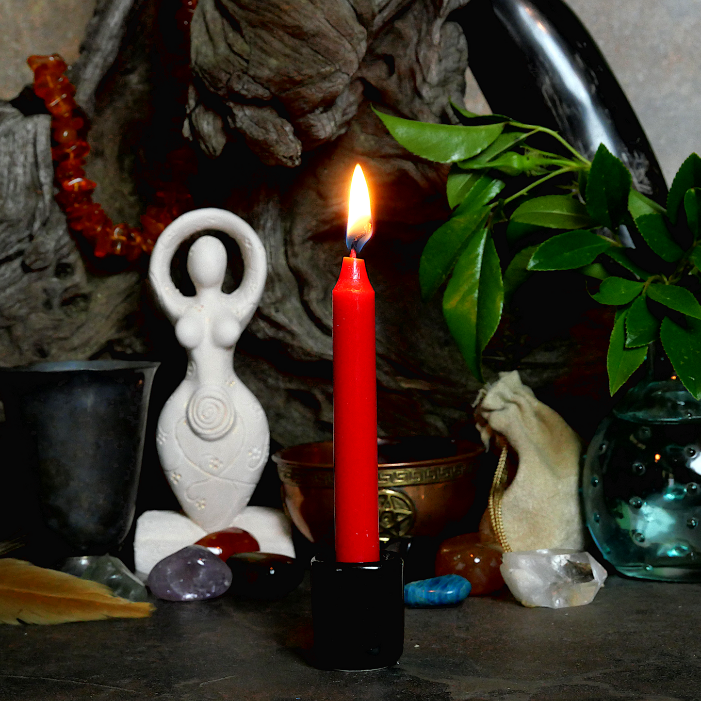 A lit Red Chime Candle, in a personal altar display, showing how it might be used in a ritual or ceremonial setting.