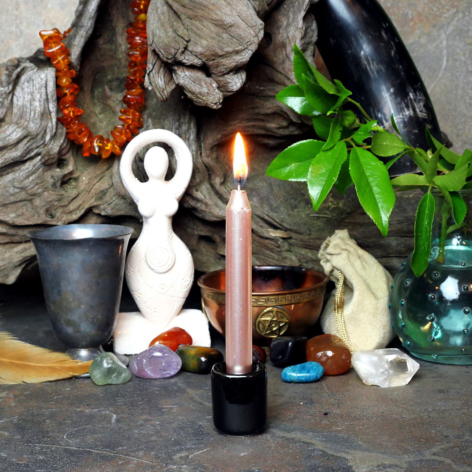 A lit Rose Gold Chime Candle, in a personal altar display, showing how it might be used in a ritual or ceremonial setting.