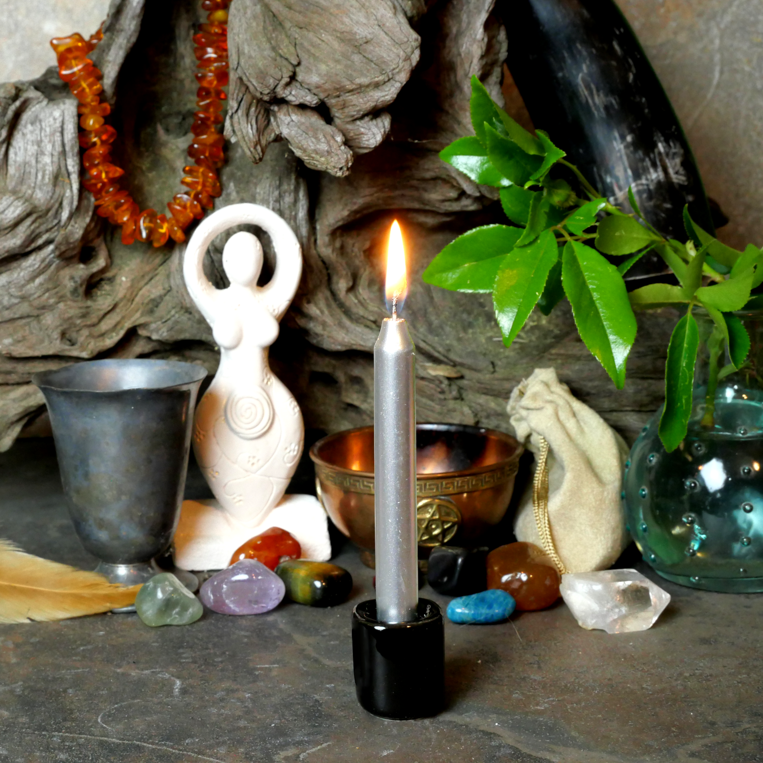 A lit Silver Chime Candle, in a personal altar display, showing how it might be used in a ritual or ceremonial setting.