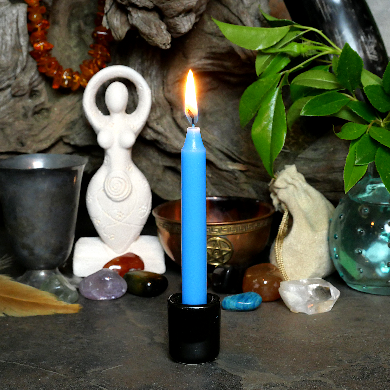 A lit Sky Blue Chime Candle, in a personal altar display, showing how it might be used in a ritual or ceremonial setting.