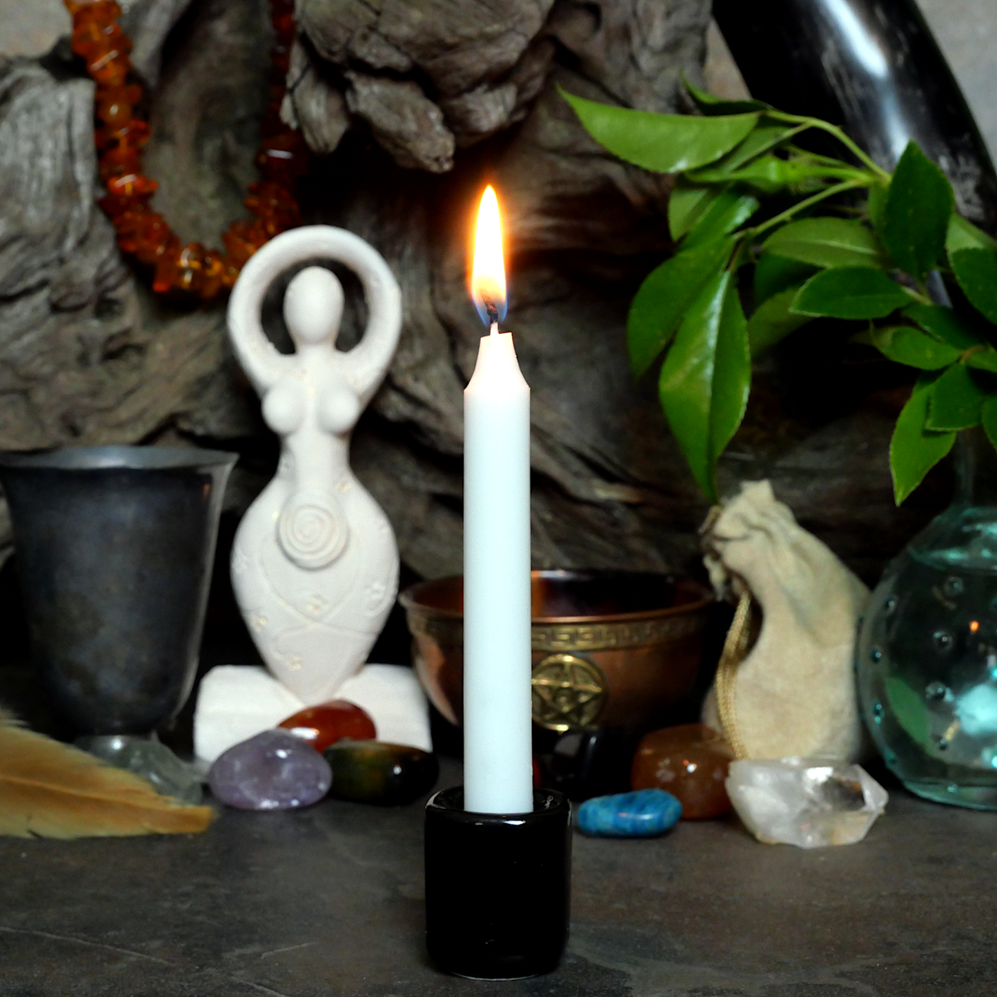 A lit White Chime Candle, in a personal altar display, showing how it might be used in a ritual or ceremonial setting.