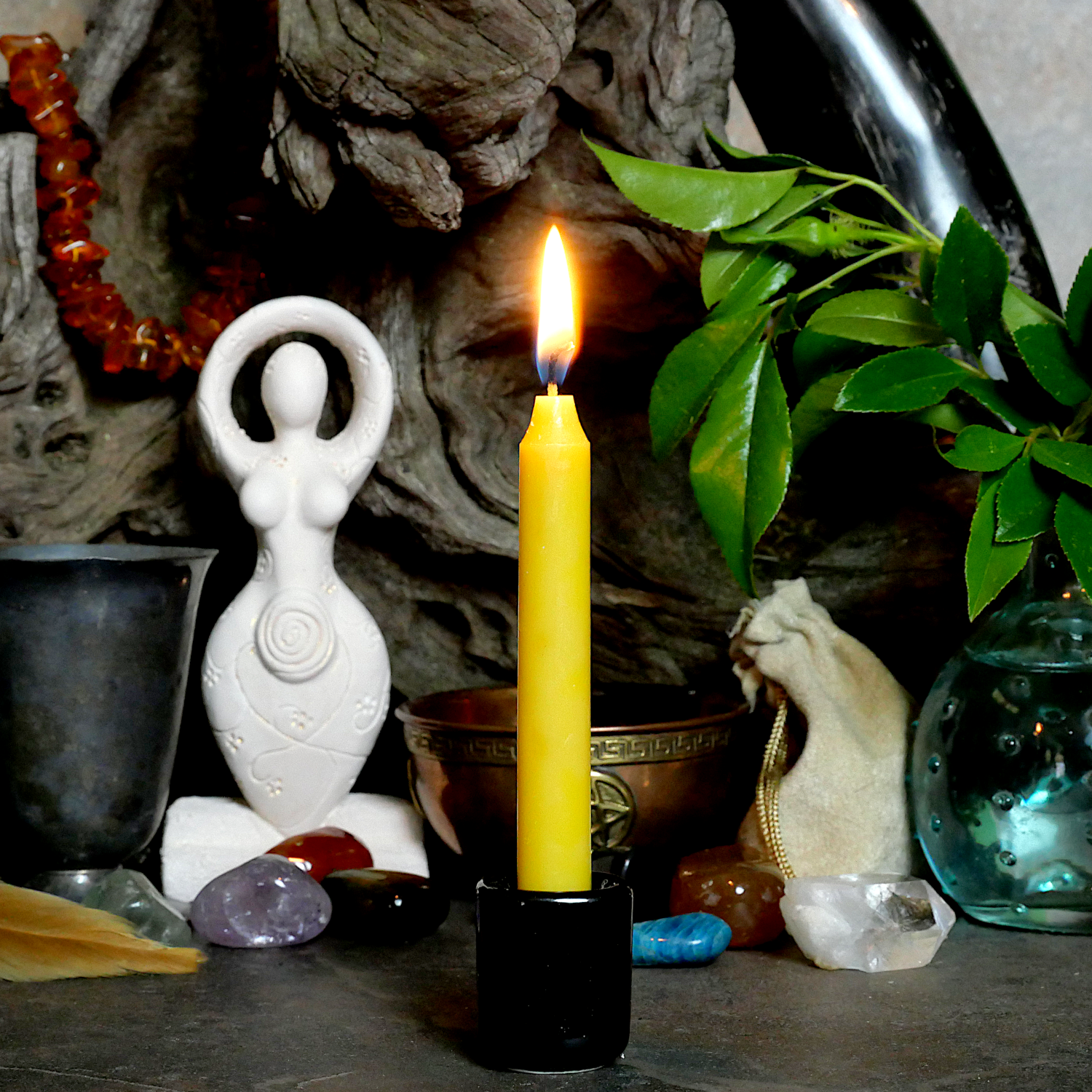 A lit Yellow Chime Candle, in a personal altar display, showing how it might be used in a ritual or ceremonial setting.