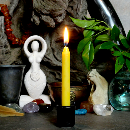 A lit Yellow Chime Candle, in a personal altar display, showing how it might be used in a ritual or ceremonial setting.