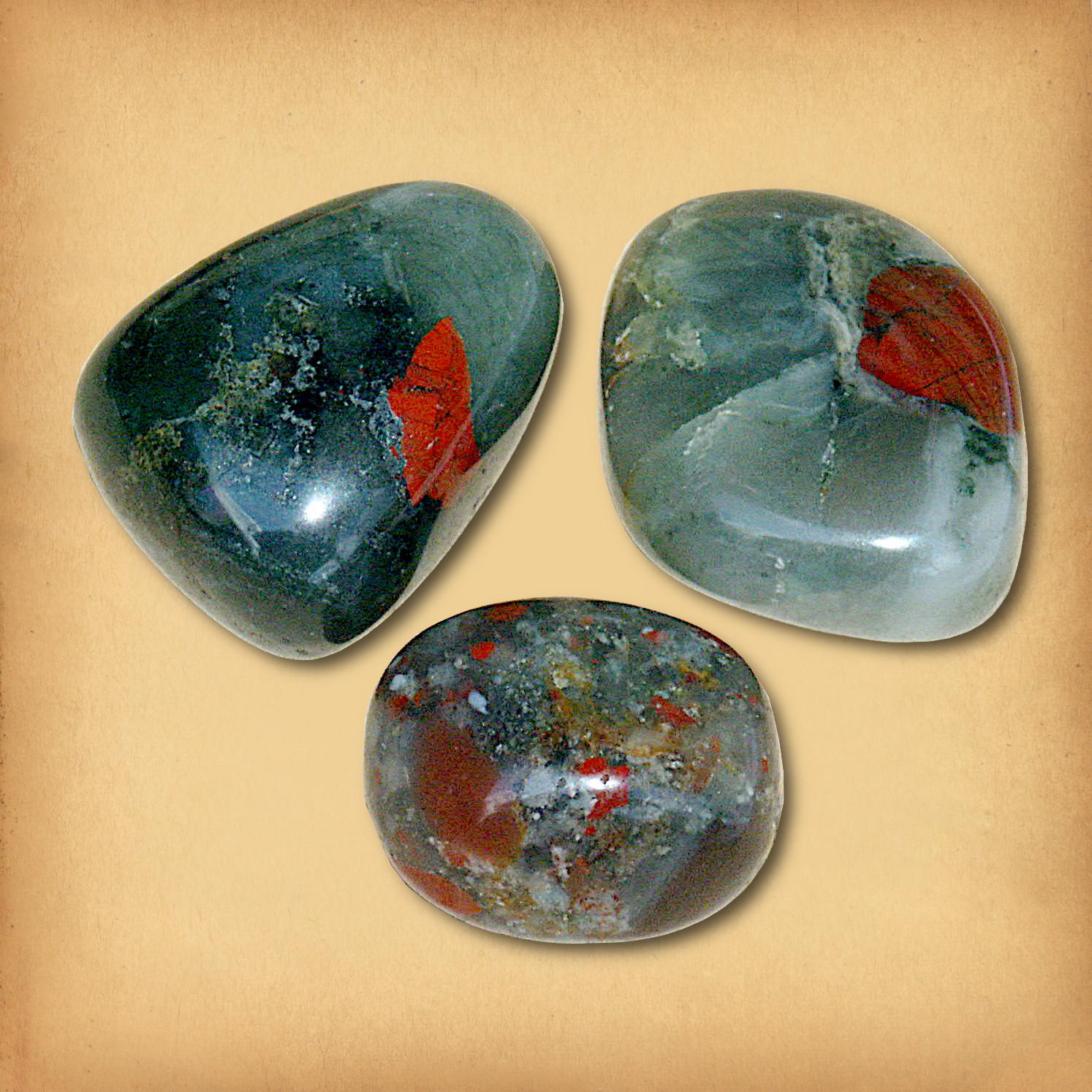 Three tumbled Bloodstone stones in mossy green hues, accented by red splashes, showing the typical variety in a set.