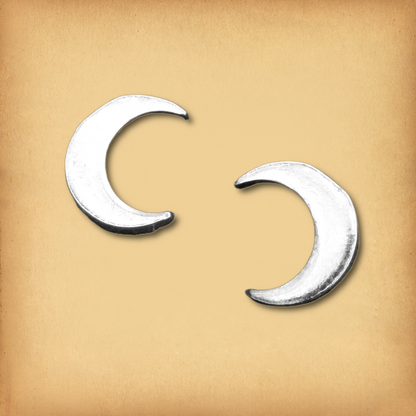 A pair of sterling silver new moon earrings, showing their graceful, uncomplicated crescent design.