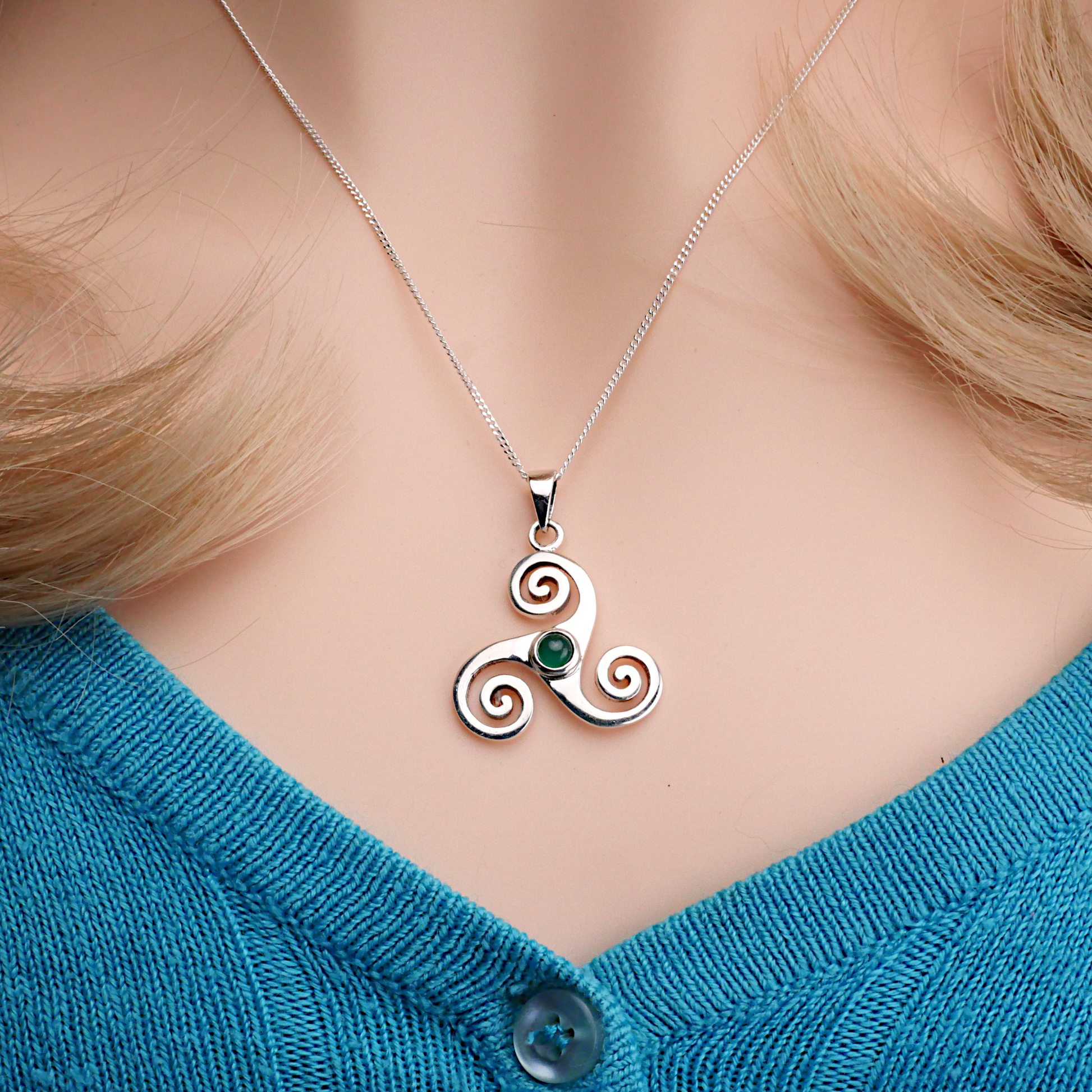 Sterling Silver Triskele Pendant with green agate, worn by a model, showcasing its delicate silver chain and Celtic design.