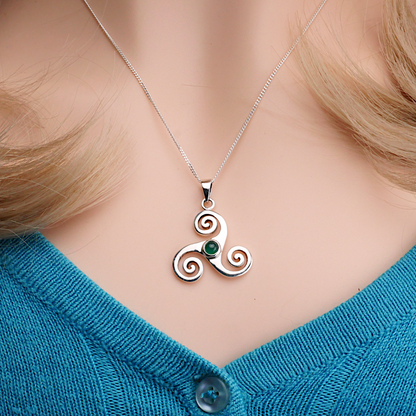 Sterling Silver Triskele Pendant with green agate, worn by a model, showcasing its delicate silver chain and Celtic design.