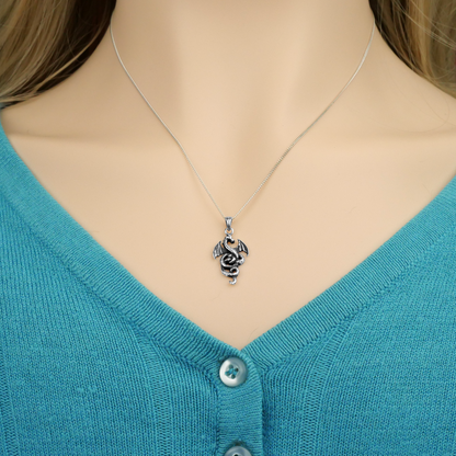 Sterling Silver Coiled Dragon Pendant worn by a model, showing the pendant hanging just above the V-neck of her sweater.