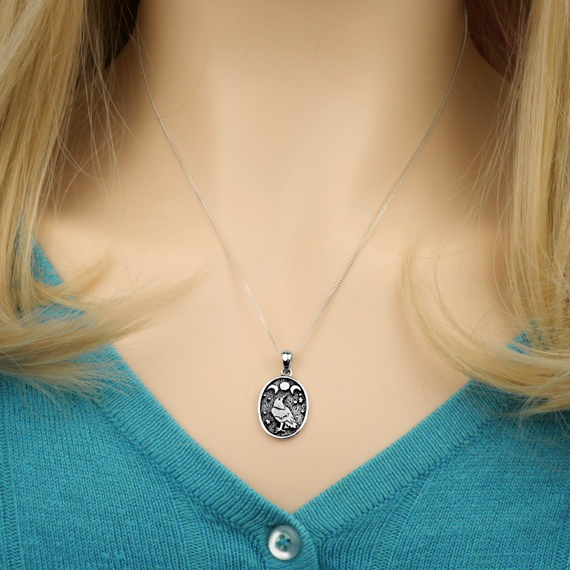 Silver Raven Moon Pendant worn by a model, showcasing its mystical design on an 18" chain. Perfect for pagans, wiccans.