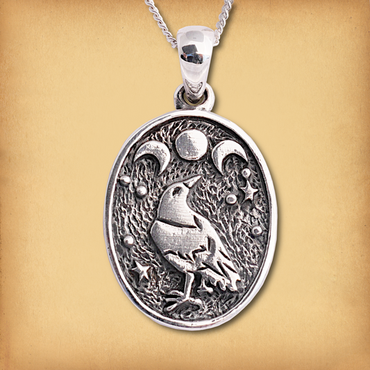 Sterling Silver Raven Moon Pendant with raven and triple moon design, surrounded by celestial symbols on textured background.