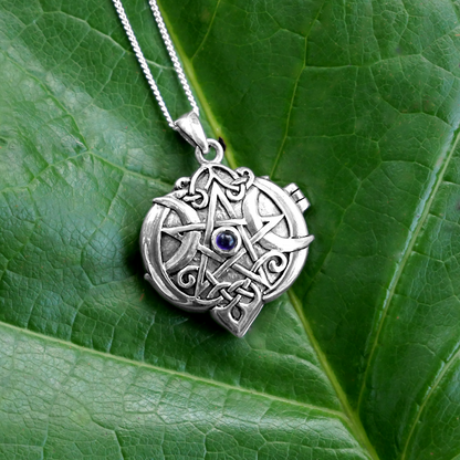 Silver Amethyst Heart Pentacle Locket displayed on a green leaf, showing the pentacle design with crescent moons and gemstone