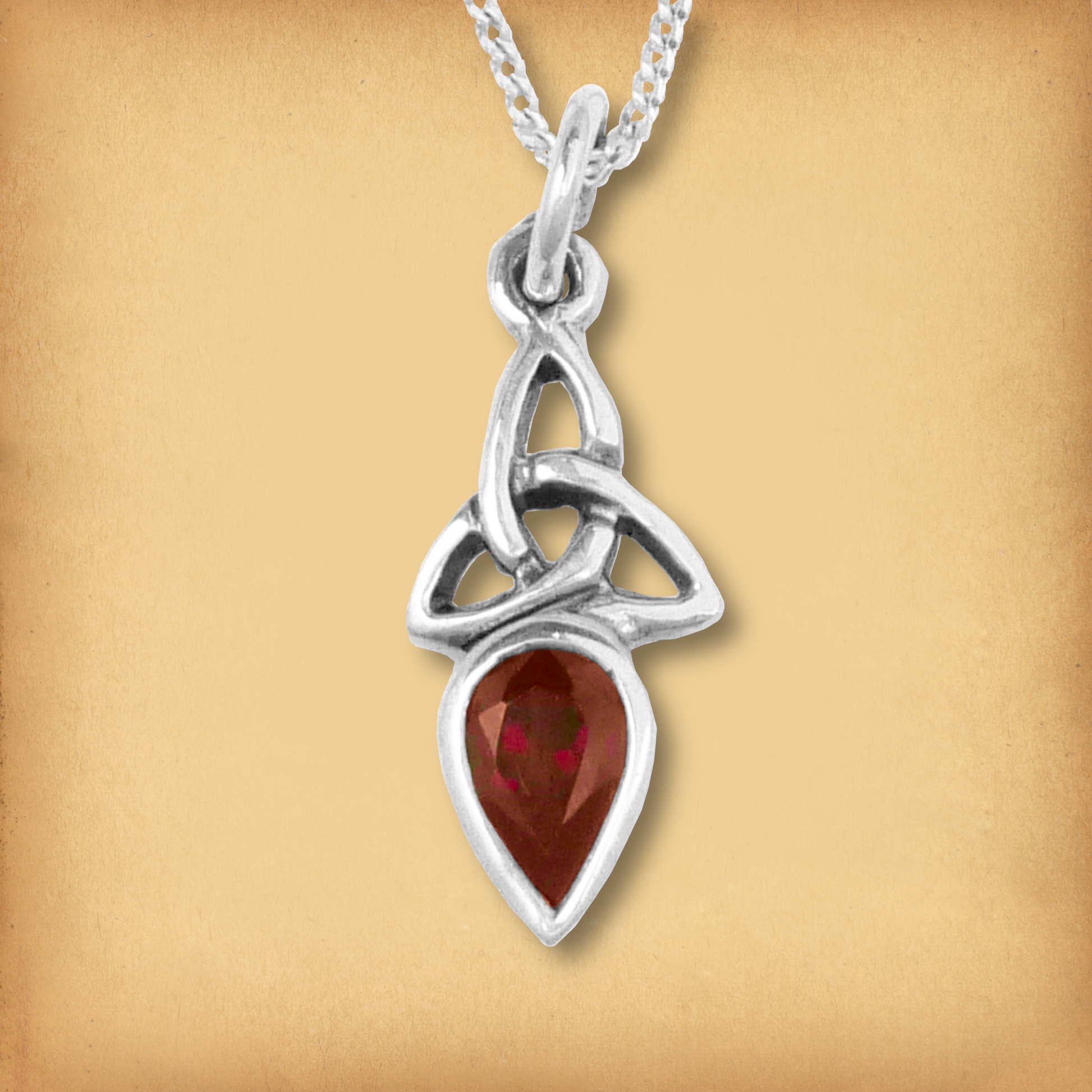 Silver Garnet Trinity Knot Pendant with a vibrant red garnet gemstone and a simple sterling silver Celtic knotwork setting.