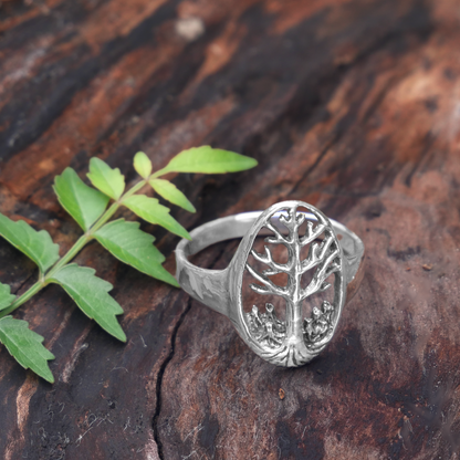 Sterling Silver Tree of Life Ring, resting on a weathered log, emphasizing its symbolic connection to growth and Nature.