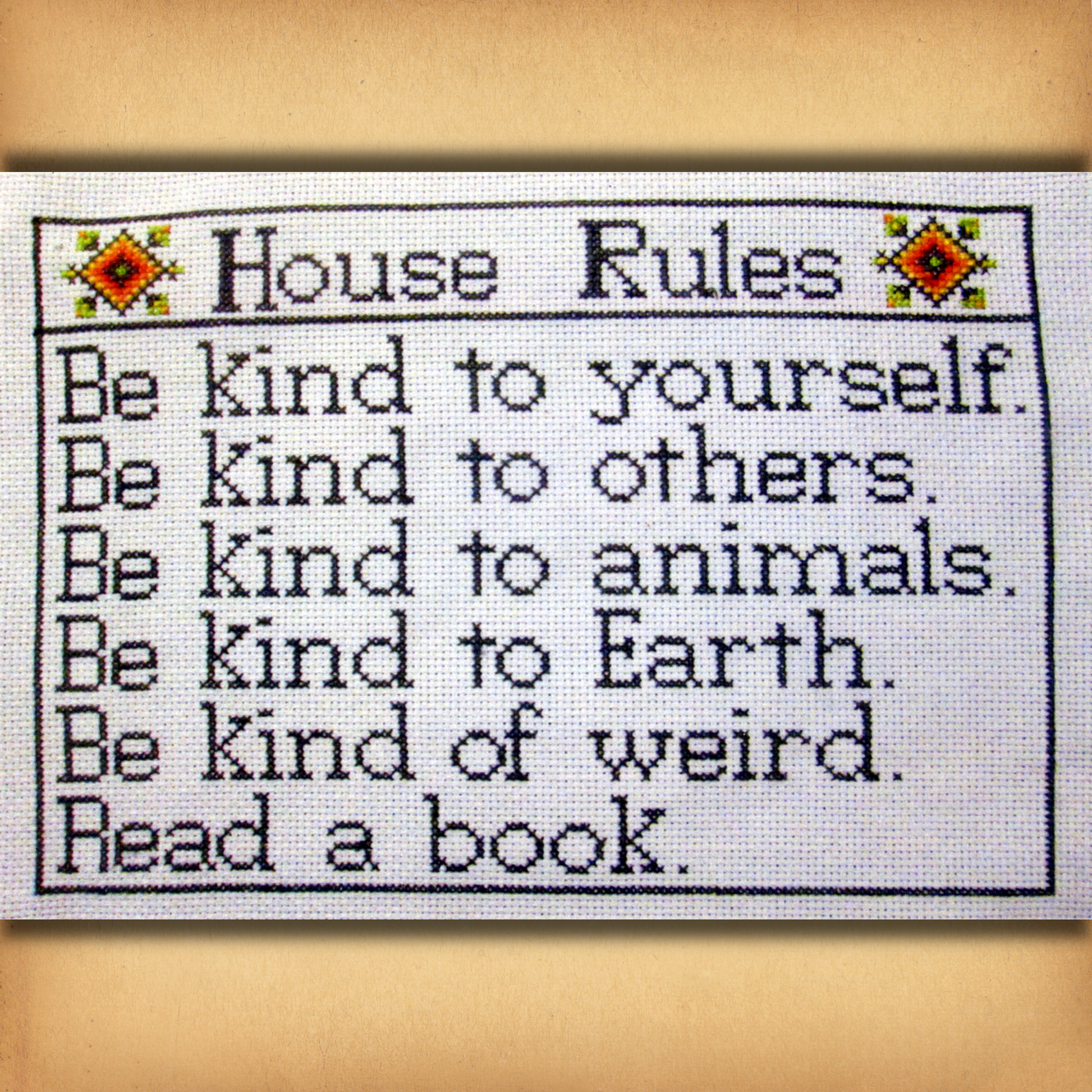 House Rules cross stitch design listing reminders to be kind, embrace weirdness, and read books, within a simple border.